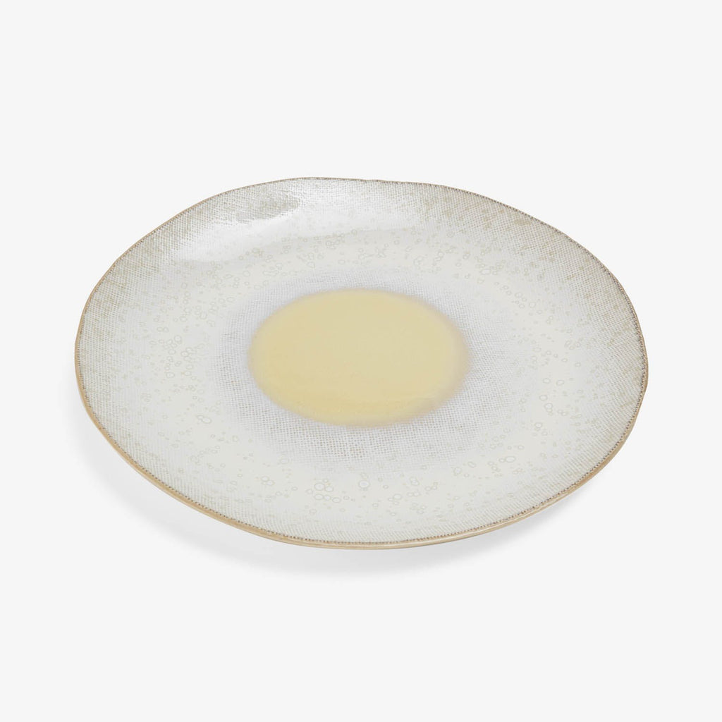 An empty plate with a speckled pattern and gold rim.