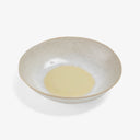 Handmade, textured bowl with a pale, glazed finish and subtle color gradation.