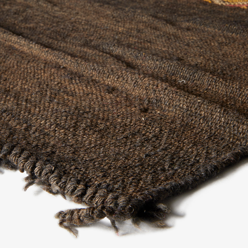 Close-up of thick, dark brown knitted fabric with visible weave.