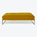 Contemporary ottoman bench with plush mustard yellow upholstery and tufted cushion.