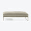 Modern minimalist ottoman with plush cushion and sleek metal legs.