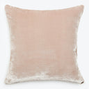 Pale pink velvet decorative pillow with subtle distressed texture.