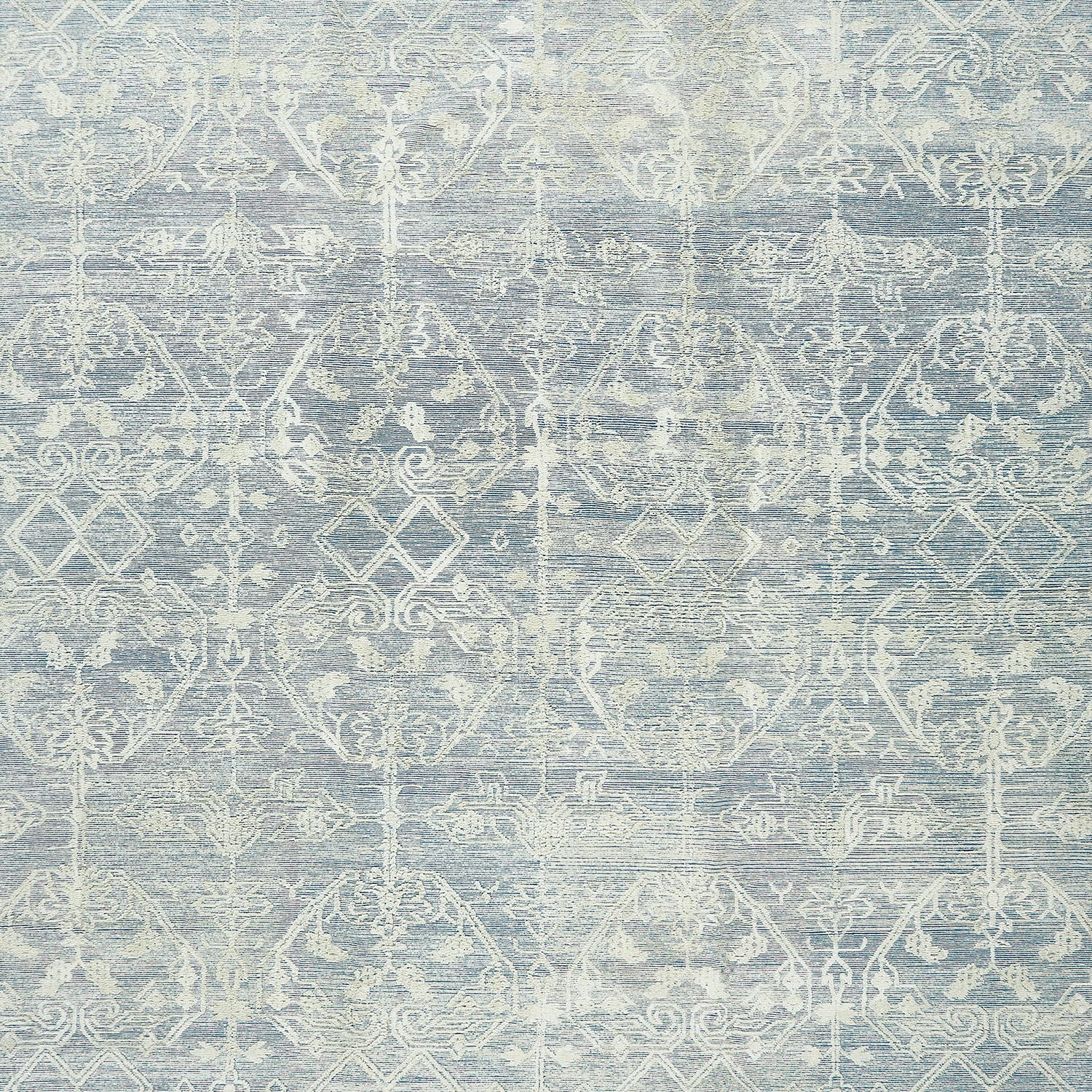 Vintage-inspired textured surface with symmetrical motifs in muted blues.