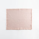 Light pink fabric square with frayed edges against white background.