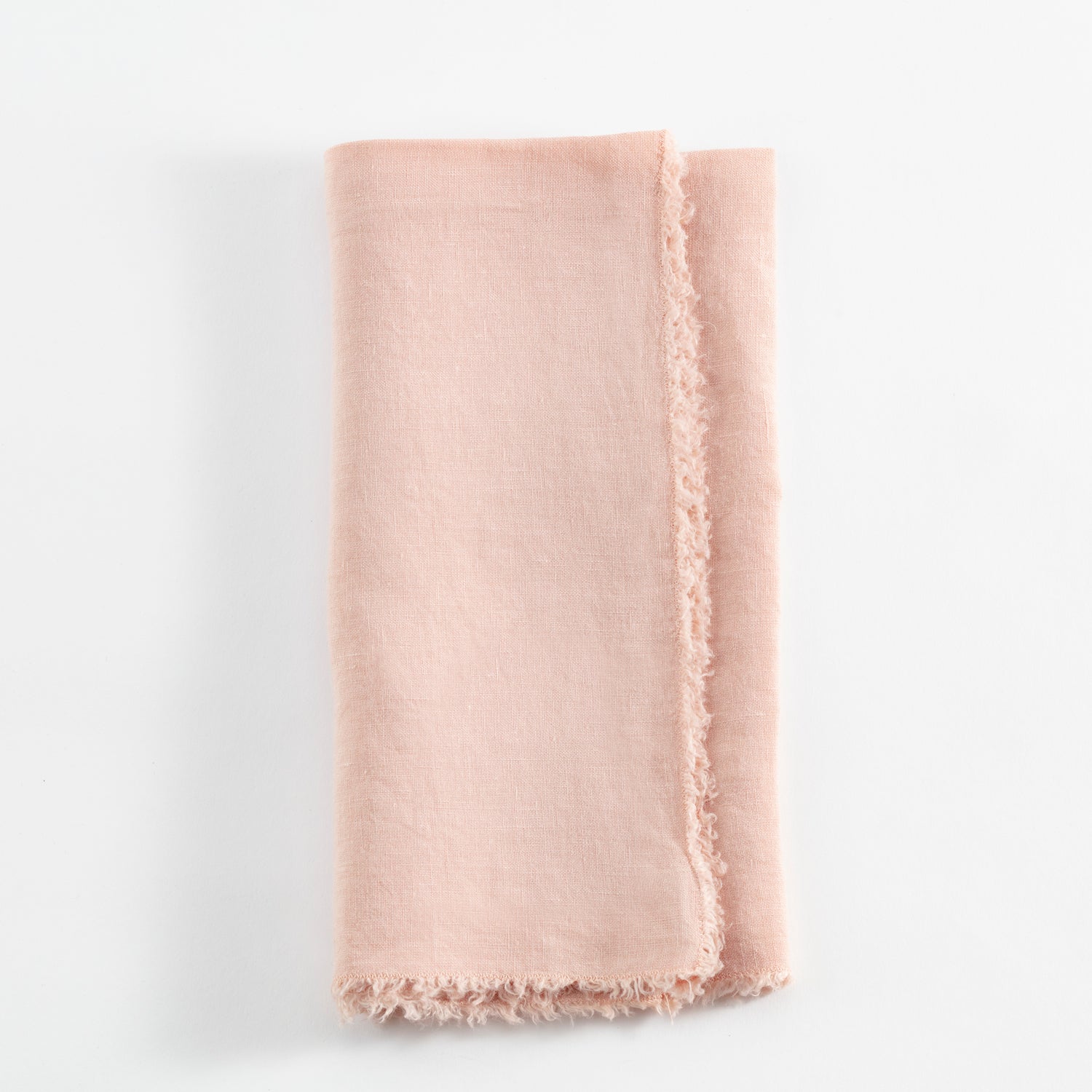 Soft pink sheer fabric with frayed edges on white background.