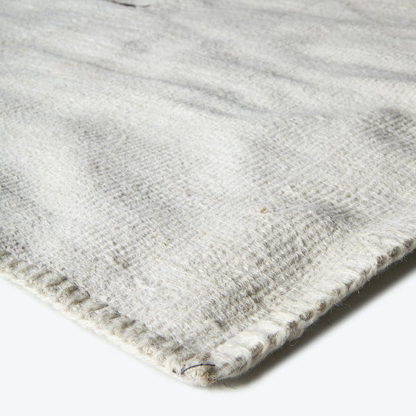 Close-up of light-colored textured fabric with noticeable weave pattern.