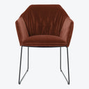 Contemporary armchair with rich velvet upholstery and minimalist metal legs.