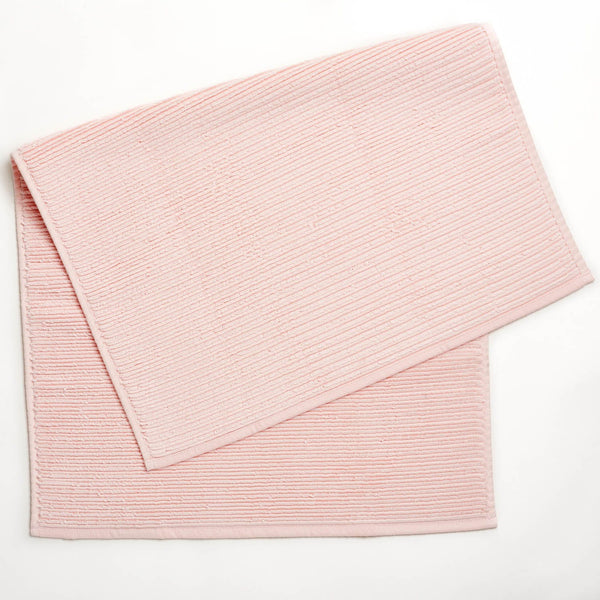 Dusty pink cloth napkins with ribbed texture on white background.