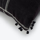 Close-up of a black decorative pillow with white stitched lines.
