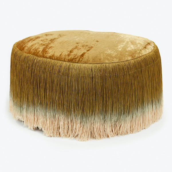 Velvet-covered ottoman with gradient fringes adds a stylish touch.