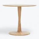 Round wooden table with single central support, light-colored and stable.