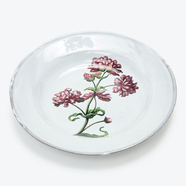 Hand-painted ceramic plate with vintage floral design on rustic background.