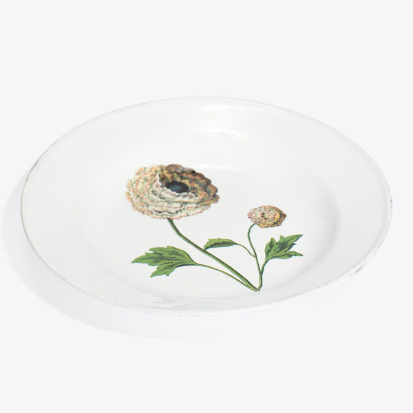 White ceramic dish with artistic floral design in center.