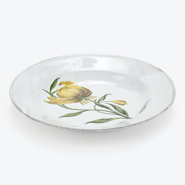 Handcrafted circular plate with a simple floral illustration centerpiece.
