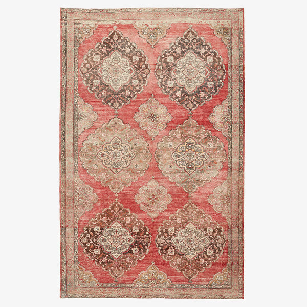 An ornate handwoven rug showcasing rich red tones and intricate patterns.