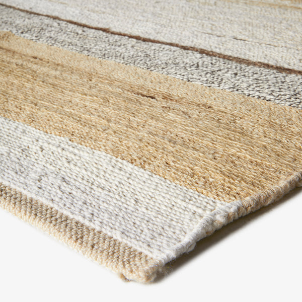 Striped wool rug in beige, white, and grey; tightly bound.