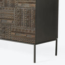 Ornately designed storage cabinet with geometric relief patterns and sleek legs.