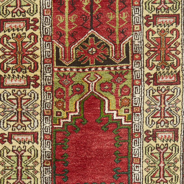 Close-up of a high-quality, intricately patterned prayer rug with symmetrical motifs and harmonious color contrast.