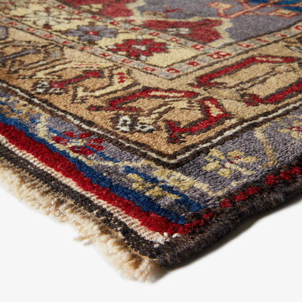Close-up of a hand-woven, intricately patterned rug with rich colors.