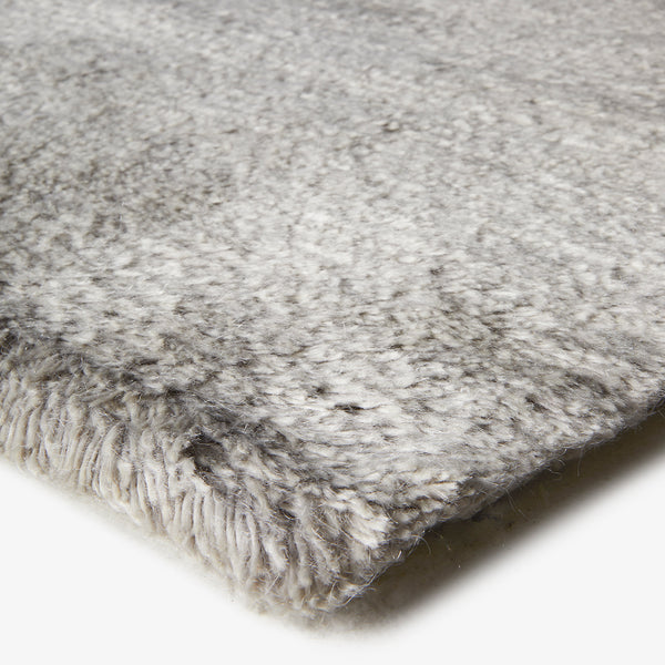 Close-up of a gray, high-pile textured fabric with fringed edges.