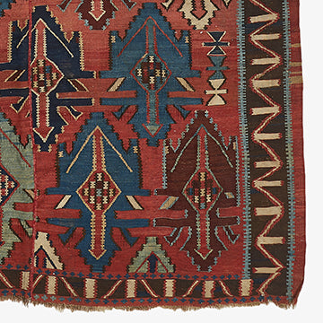 Intricate tribal rug with dark red and blue geometric patterns.