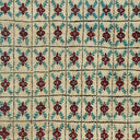 Close-up of a cream, dark red, and teal patterned carpet.