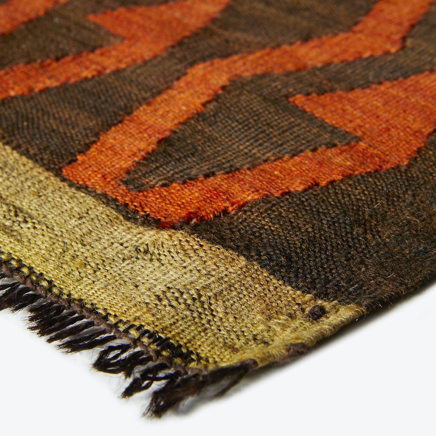 CLOSE-UP: Vibrant, zigzag striped textile with fringed edge and coarse fibers.
