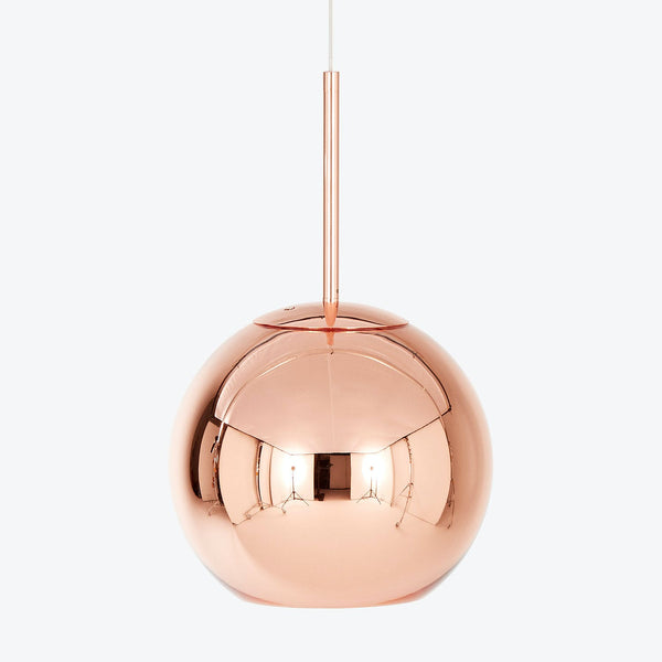 Contemporary copper pendant light with sleek spherical design and warm glow.