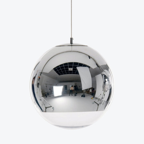 Reflective pendant light captures panoramic view of professional media studio.