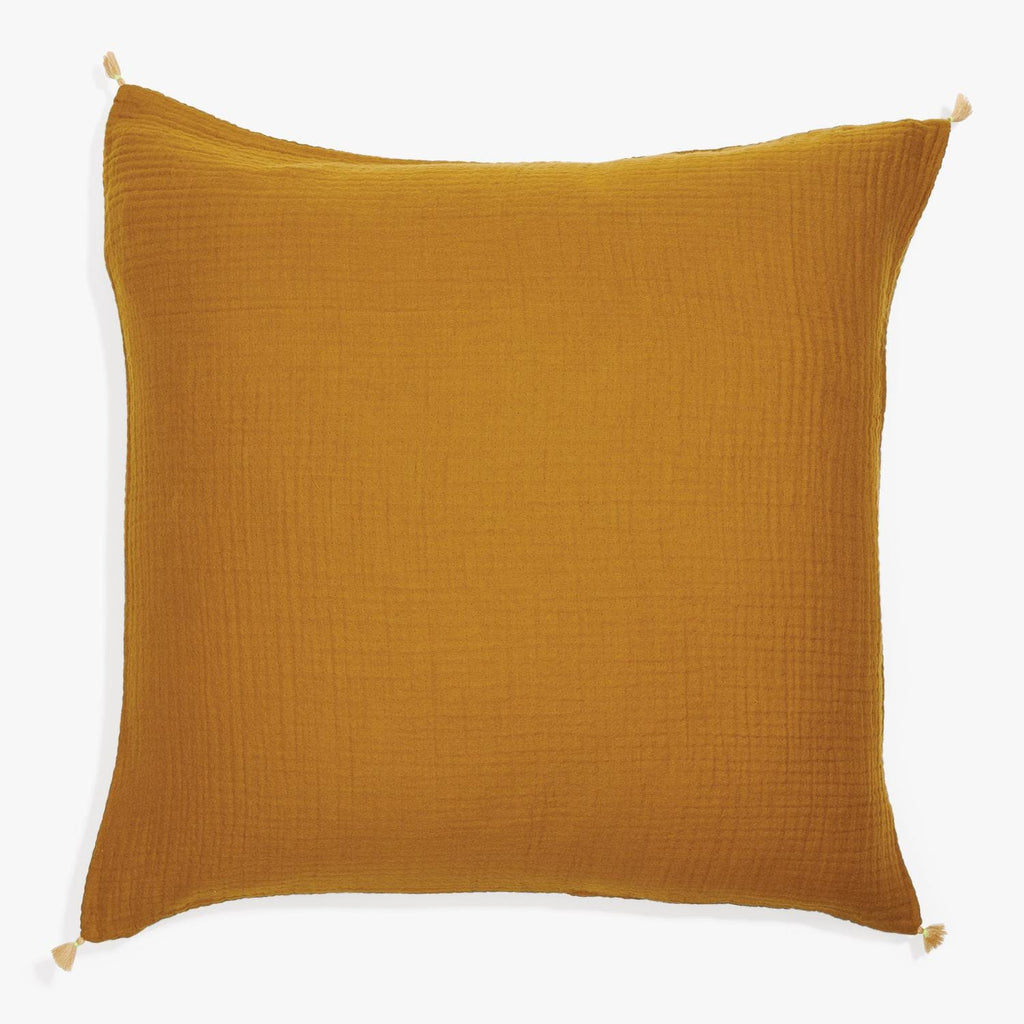 Mustard yellow pillow with tassel details adds cozy decor touch.