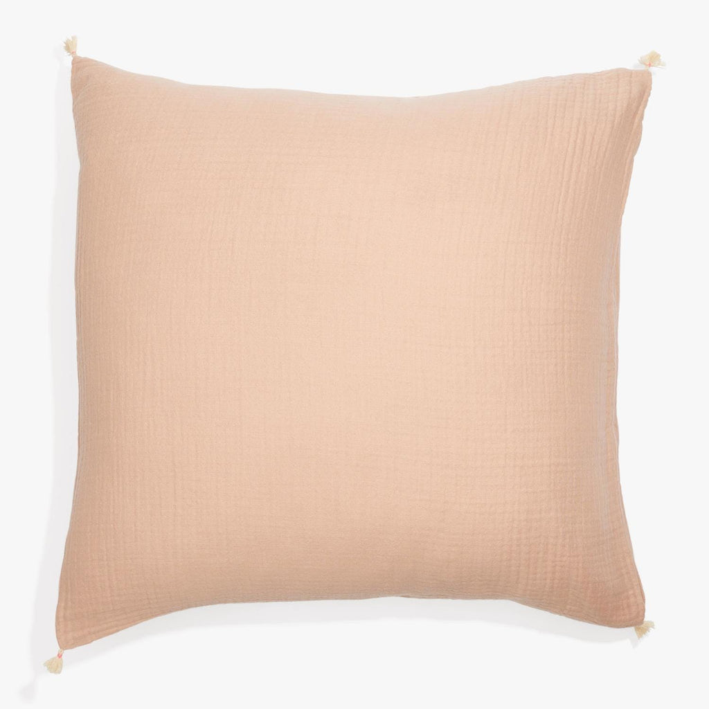 Square pillow in light peach with textured waffle weave fabric.