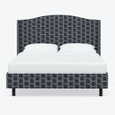 Minimalist bed with geometric patterned headboard and matching upholstery.