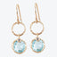 Elegant gold-tone earrings with blue gemstones and sparkling accents.