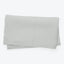 Soft and cozy light gray textured blanket on white background.