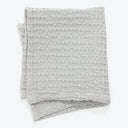 Folded gray blanket with plush ripple design, neatly displayed.