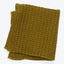 Olive green blanket with embossed, three-dimensional pattern and plush texture.