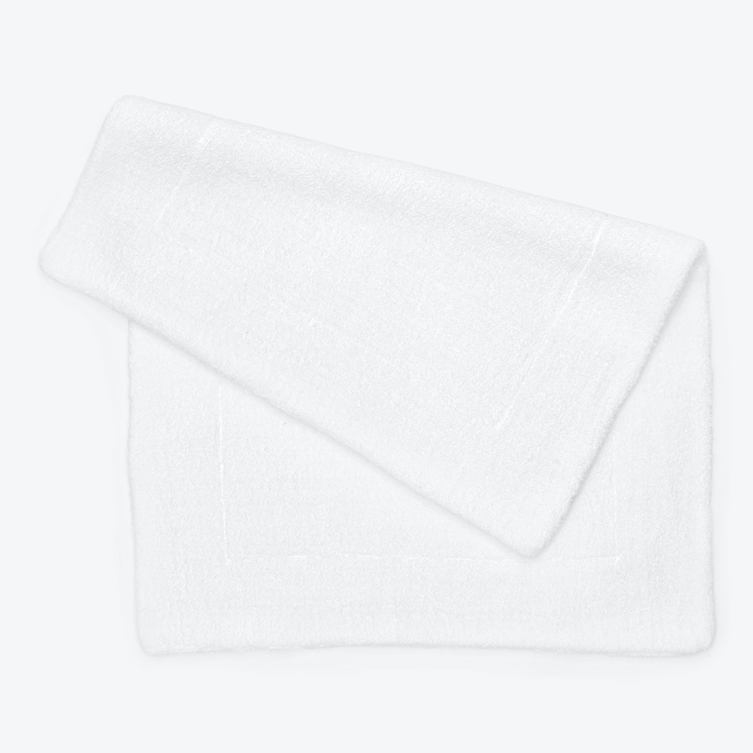 Neatly folded, plush white towel against a minimalist background.
