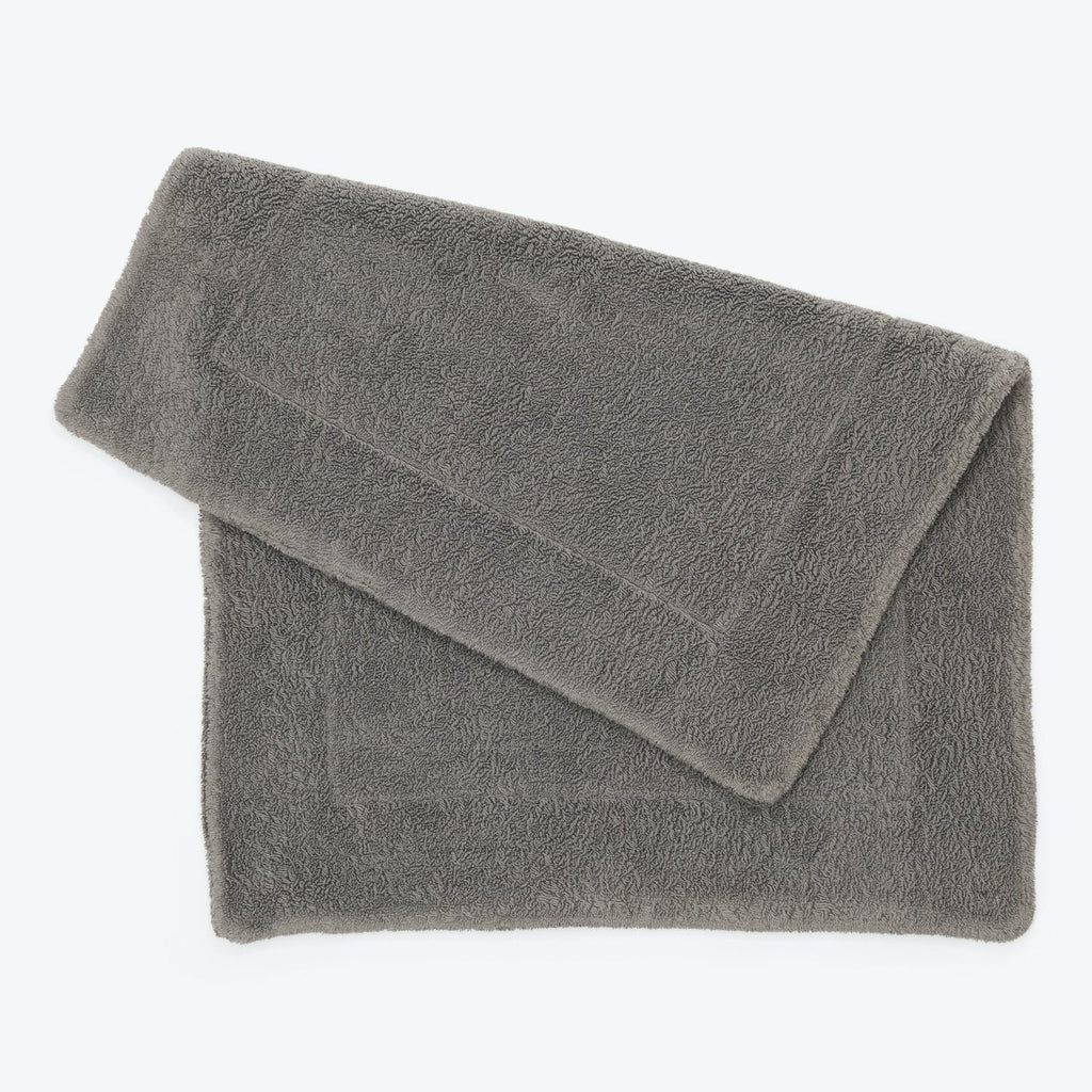 Folded gray bath towel showcasing its soft, fluffy texture and absorbency.
