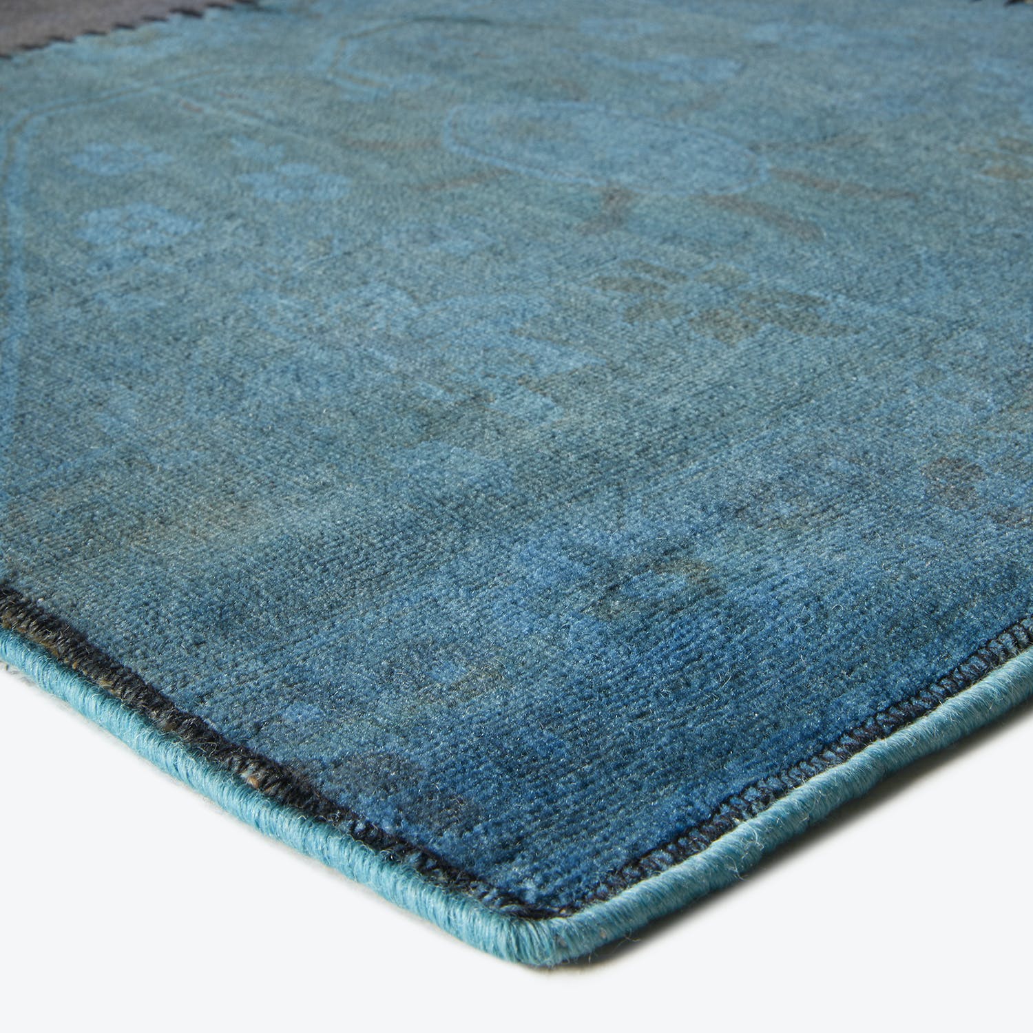 Close-up of a faded blue rug with plush, textured fibers.