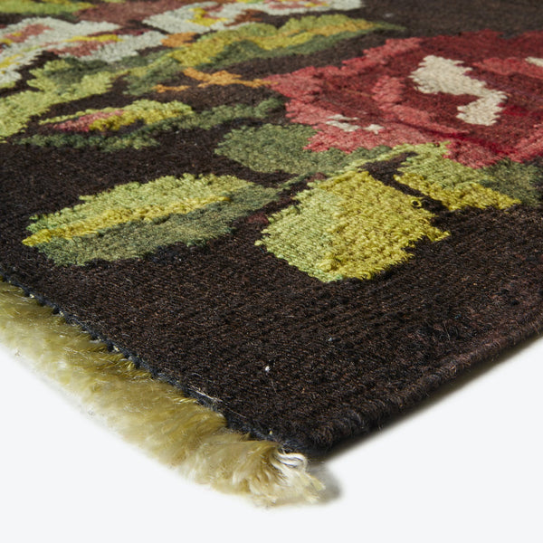 Close-up of a high-pile rug with leaf-shaped patterns in warm colors.