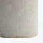 Close-up of speckled ceramic vase, off-white with brown flecks.