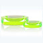 Two fluorescent green ashtrays on a reflective white surface.