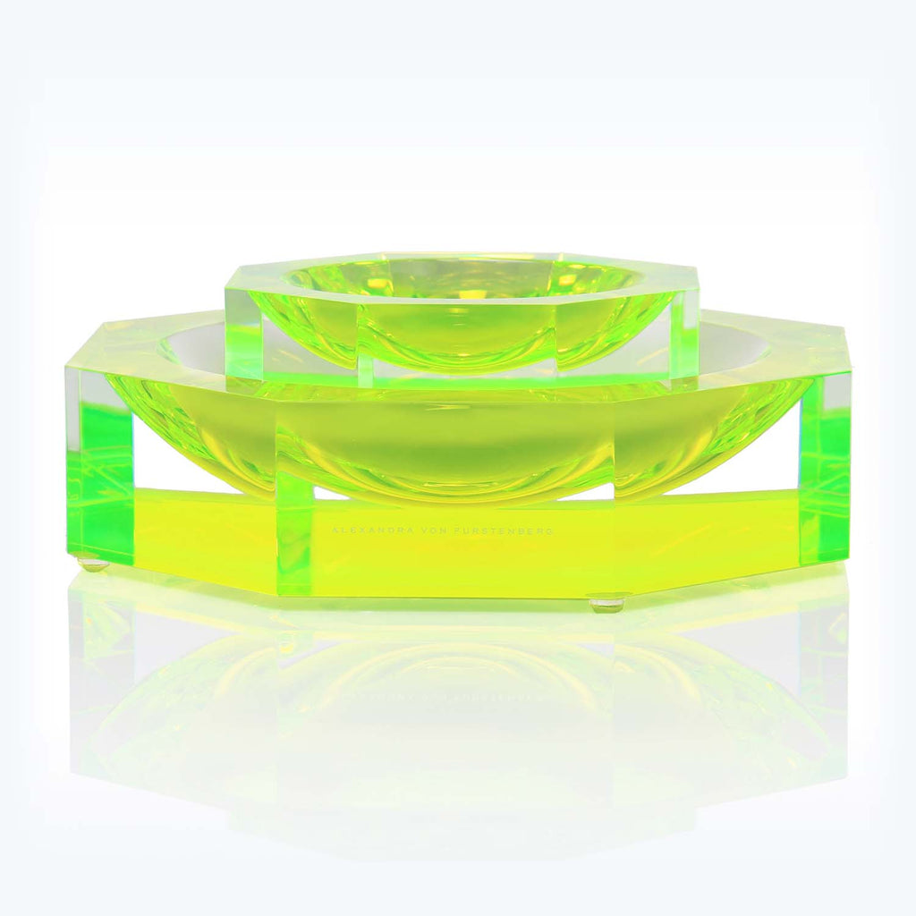 Contemporary green acrylic bowl set on a sleek tray surface.