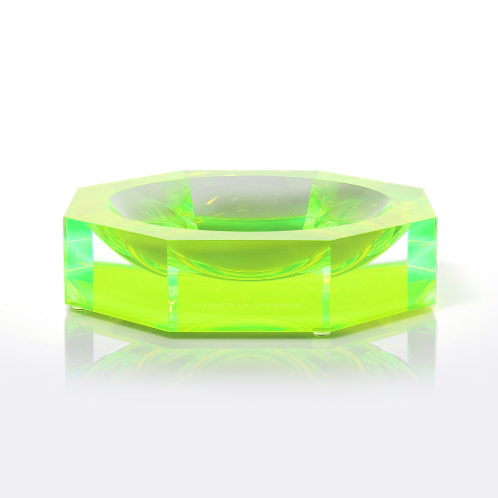 Vibrant green hexagonal glass-like object with sparkling facets and reflection.
