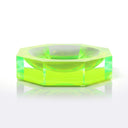 Vibrant green hexagonal glass-like object with sparkling facets and reflection.
