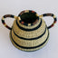 Handcrafted basket with classic pottery design, made with coiled basketry technique and natural fibers. Features two handles and decorative black stripes.