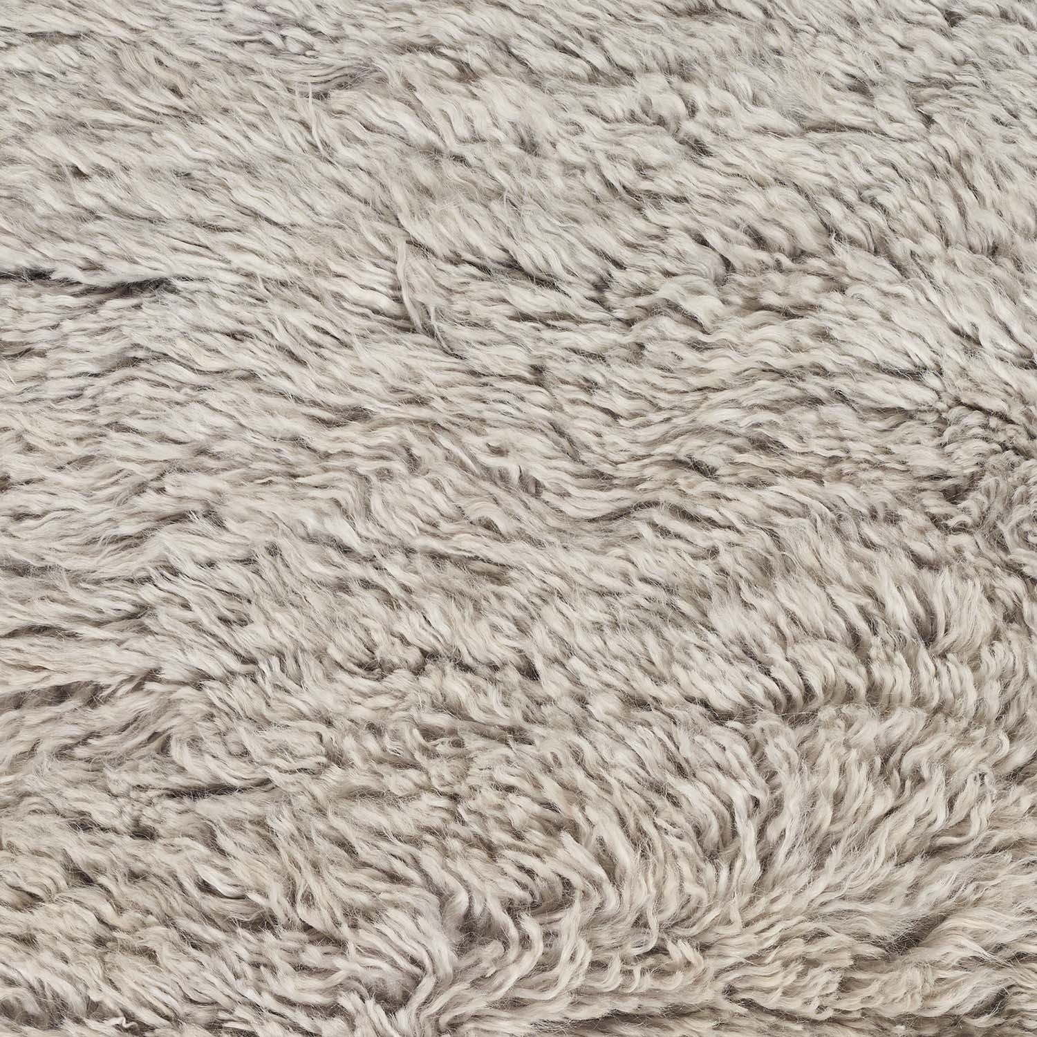 Close-up of a plush, shaggy fabric in neutral tones.