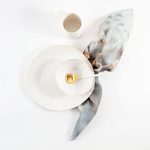 Minimalist breakfast or tea service on white background with marble fabric.