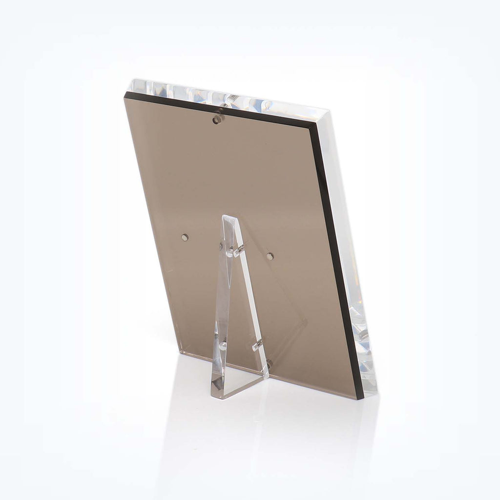 Transparent acrylic photo frame with metallic fasteners on white background.