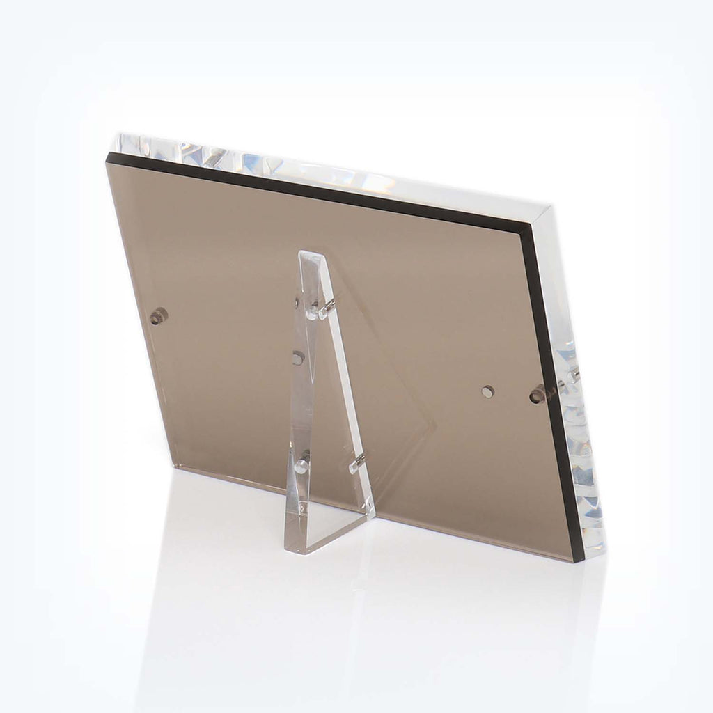 Modern, minimalist acrylic photo frame with magnetic corner attachments.